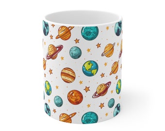 May include: White ceramic mug with a repeating pattern of colorful planets and stars. The planets are drawn in a cartoon style and include Earth, Saturn, Jupiter, and other planets.