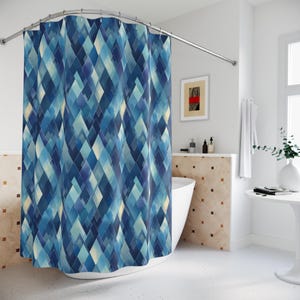 May include: A blue shower curtain with a geometric diamond pattern in shades of blue and cream. The curtain hangs from a curved metal rod, adding a modern touch to the bathroom decor. The design creates a visually appealing and stylish look.