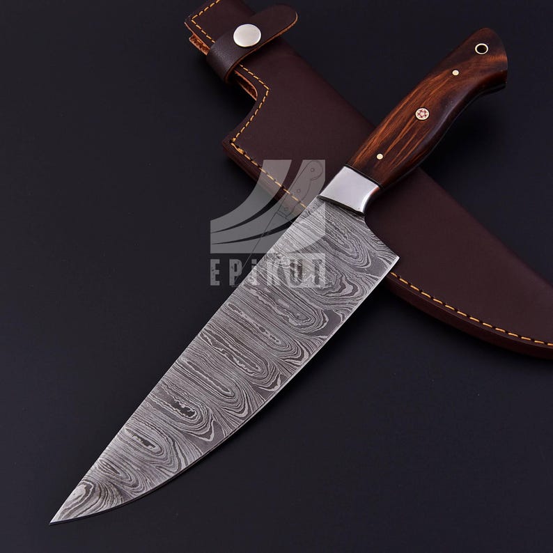 May include: A Damascus steel chef's knife with a wooden handle and a leather sheath. The blade has a wavy pattern and is very sharp.