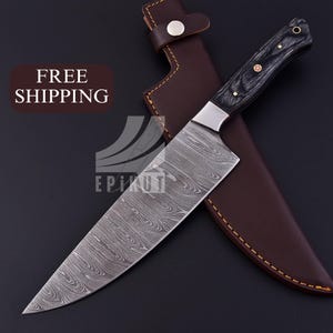 May include: A Damascus steel chef's knife with a black wood handle and a leather sheath. The knife has a wavy pattern on the blade and a gold accent on the handle.