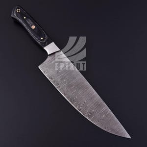 May include: A black handled chef's knife with a Damascus steel blade. The blade has a wavy pattern and a pointed tip.