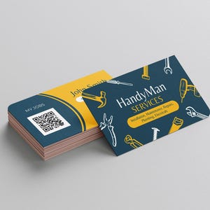 Puede incluir: Una tarjeta de visita azul y amarilla con el texto "Handy Man Services" y una lista de servicios: Instalaci&oacute;n, Mantenimiento, Reparaciones, Fontaner&iacute;a, Electricidad. La tarjeta est&aacute; decorada con una variedad de herramientas, incluyendo un martillo, una llave, un destornillador y una sierra.