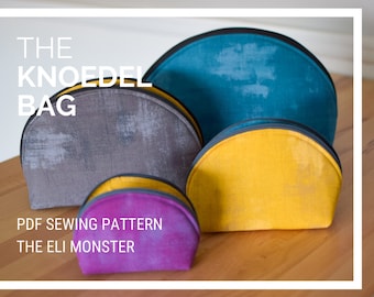 May include: Four different sized half-circle shaped fabric bags in teal, yellow, purple, and gray. The bags have a black trim around the edges. The bags are arranged in a row on a wooden surface. The text "THE KNOEDEL BAG" is at the top of the image. The text "PDF SEWING PATTERN THE ELI MONSTER" is at the bottom of the image.