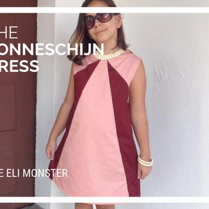 May include: A young person wearing a pink and burgundy sleeveless dress with a white necklace. The dress has a geometric pattern. The text "THE ZONNESCHIJN DRESS" and "THE ELI MONSTER" are visible in the image.