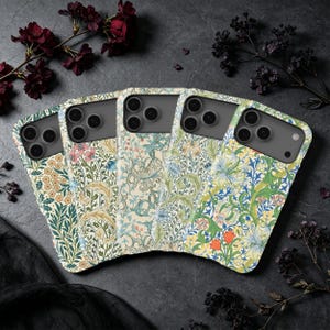 May include: Five smartphone cases arranged in a fan shape, each featuring a distinct intricate floral and botanical pattern with colours including cream, green, blue, yellow, and orange. Each case has a cutout for a triple-lens camera system.