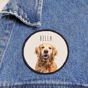 May include: A round patch featuring a Golden Retriever dog with the name "BELLA" above the dog's image. The dog has a happy expression. The patch is on a denim jacket.