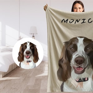 May include: A personalized fleece blanket with a brown and white dog illustration and the name "MONICA" printed in black text.