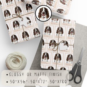 May include: White wrapping paper with a repeating pattern of a brown and white dog's face in a square frame with the word "ROSA" written below. The paper is available in glossy or matte finish and in three sizes: 30 inches by 36 inches, 30 inches by 72 inches, and 30 inches by 180 inches.