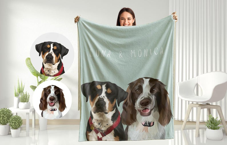May include: A soft, light blue fleece blanket with the names "Luna & Monica" printed on it. Two dog portraits are featured on the blanket, one of a black and white dog and one of a brown and white dog.