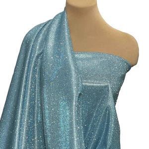 May include: A light blue fabric with a sparkly, iridescent finish. The fabric is draped over a dress form.