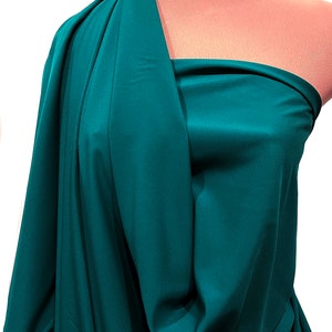May include: A teal fabric swatch draped over a mannequin. The fabric has a smooth, silky texture.