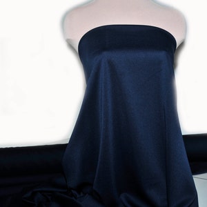May include: A dark blue fabric swatch draped over a mannequin. The fabric has a smooth, slightly textured surface.