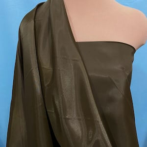 May include: A smooth, dark brown fabric with a slight sheen. The fabric is draped over a mannequin's shoulders.
