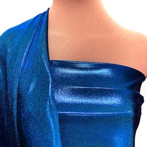 May include: A close-up of a blue metallic fabric with a slight sheen. The fabric is draped over a mannequin's shoulders.