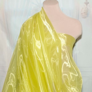 May include: A bright yellow sheer fabric with a slight sheen. The fabric is draped over a dress form.