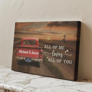 May include: A canvas print featuring a vintage red truck on a dirt road at sunset. The truck's tailgate displays "Michael & Janet" and a license plate. Text reads "ALL OF ME loves ALL OF YOU."