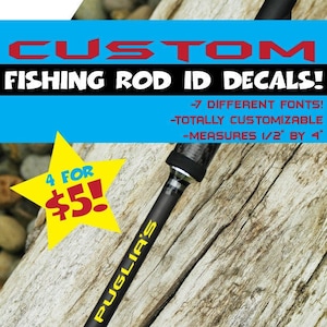 May include: A close-up of a black fishing rod with a yellow "PUGLIA'S" label. The rod is on a wooden surface with a blue and red sign that reads "CUSTOM FISHING ROD ID DECALS!" with the following details: "4 FOR $5! -7 DIFFERENT FONTS! -TOTALLY CUSTOMIZABLE -MEASURES 1/2" BY 4"