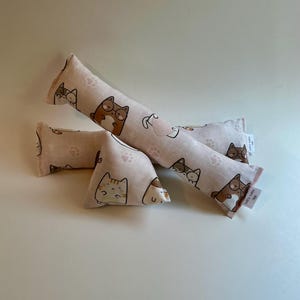 May include: A set of three ceramic mugs with a speckled, matte finish. The mugs are in cream, light grey, and dark grey. Each mug has a simple, minimalist design, ideal for coffee or tea.