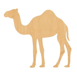 May include: A flat, light-colored wooden cutout in the shape of a camel. The object features a smooth, natural wood grain texture and a distinct silhouette of a single-humped camel standing in profile, facing toward the left side of the frame.