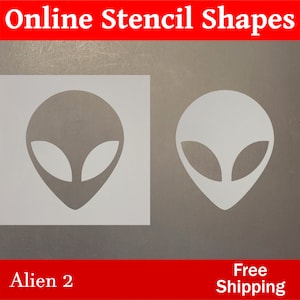 May include: Two white alien head stencils on a gray background. The stencils are in the shape of an alien head with large eyes and a pointed chin. The text "Alien 2" is below the stencils and the text "Free Shipping" is below the stencils on the right side.