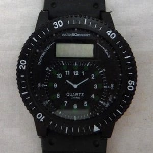 May include: Black quartz watch with a digital display and a black rubber strap. The watch face features white numerals, a tachymeter, and the text "WATER 50M RESIST". The watch is marked "CHINA".