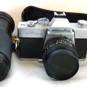 Minolta SRT 100x 35mm Film SLR Camera 50mm 1.14 f D Rokkor-X 100 - 200mm 1.5.6 zoom lens Hoya 55mm Polarizer filter Kodak strap working
