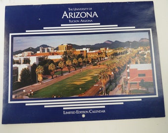 May include: A blue and white calendar with the text "The University of Arizona, Tucson Arizona" and "Limited Edition Calendar". The image shows an aerial view of the University of Arizona campus with buildings, trees, and a grassy area.