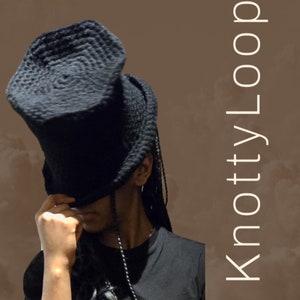 May include: A person wearing a black, crocheted hat that covers their eyes. The hat has a unique, rounded shape. The person is wearing a black shirt and has long, black braids.