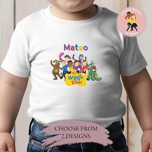 May include: White t-shirt featuring a colorful graphic of The Wiggles characters, the name "Mateo" in purple, and the text "It's Wiggle Time!" in yellow. The shirt also has a design choice option.