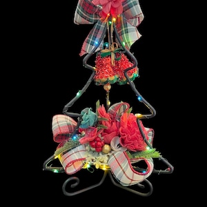 Verlichte kerstboom met houten bloemen, hoge kerstboom met gekleurde lampjes, kerstversiering