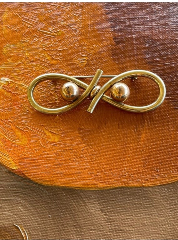 Gold and rose gold tone broach.