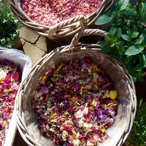 Pu&ograve; includere: Tre cesti di vimini pieni di petali di fiori colorati. I cesti sono disposti su una superficie di pietra. I petali sono un mix di rosa, viola, giallo e bianco.