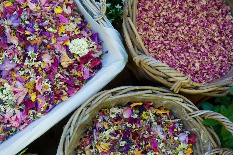 Pu&ograve; includere: Tre cesti di vimini pieni di petali di fiori secchi. I cesti sono pieni di una variet&agrave; di colori, tra cui rosa, viola, giallo e bianco.