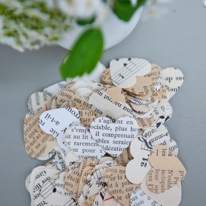Puede incluir: Un mont&oacute;n de confeti en forma de coraz&oacute;n hecho de partituras de m&uacute;sica recicladas. El confeti es en tonos crema, blanco y marr&oacute;n. El confeti presenta notas musicales y texto en franc&eacute;s.