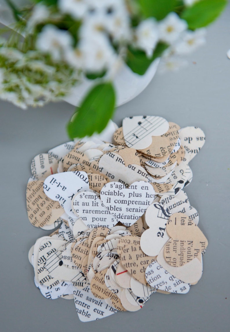 Puede incluir: Un mont&oacute;n de confeti en forma de coraz&oacute;n hecho de partituras de m&uacute;sica recicladas. El confeti es en tonos crema, blanco y marr&oacute;n. El confeti presenta notas musicales y texto en franc&eacute;s.