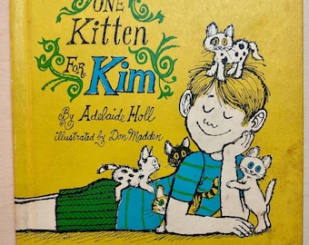 Un gatito para Kim, de Adelaide Holl, es un libro clásico de tapa dura publicado por Addison-Wesley en 1969. Ilustrado por Don Madden. Primera edición.