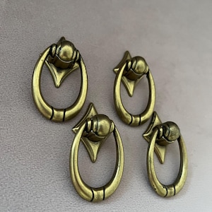 Four small vintage brass drawer pulls. Antique brass furniture knobs with classic elegance.