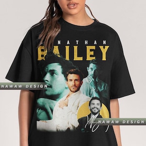 May include: Black t-shirt with a graphic print of three men. The text "NATHAN BAILEY" is printed in yellow at the top of the shirt.