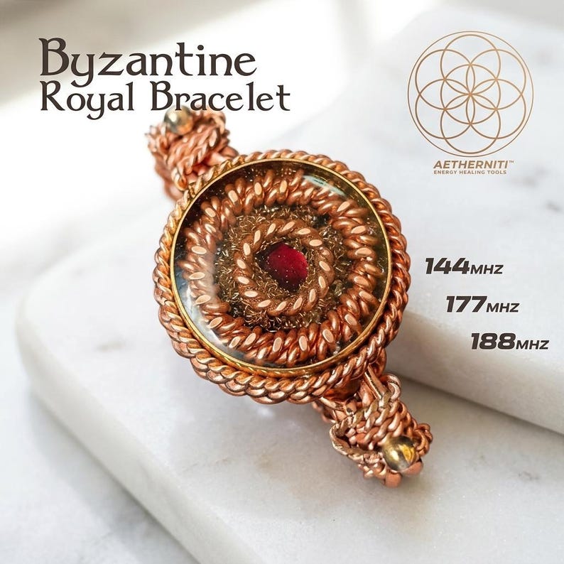 K&ouml;nnte beinhalten: Ein kupferfarbenes Armband mit einem runden Mittelst&uuml;ck, das einen roten Stein und gewickelte Drahtmuster zeigt. Der Text lautet: Byzantine Royal Bracelet, AETHERNITI ENERGY HEALING TOOLS, 144MHZ, 177MHZ, 188MHZ. Das Design umfasst geflochtene Drahtelemente.