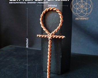 May include: An Egyptian copper ankh pendant made of twisted wire, measuring 38mm in width and 90mm in height. The text EGYPTIAN COPPER ANKH METAPHYSICAL ENERGY PENDANT and AETHERNITI ENERGY HEALING TOOLS with a geometric logo are visible.