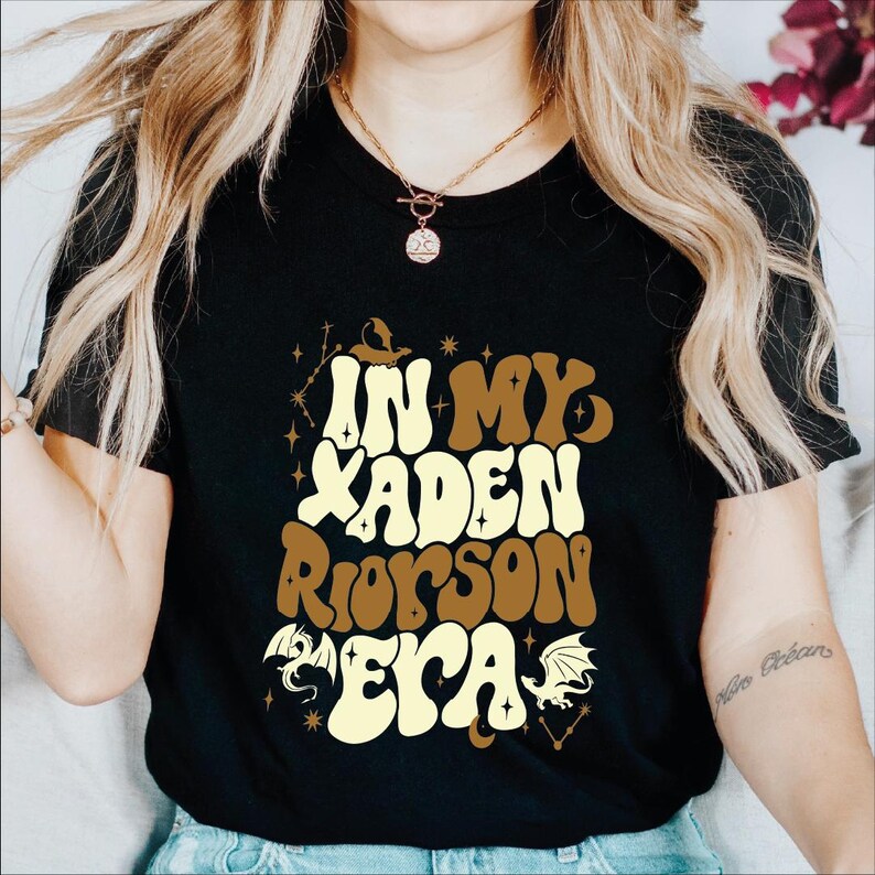 a woman wearing a black t - shirt with an orange and yellow design