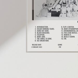 May include: A white album cover with a black border features a list of song titles and the release date, February 3, 2023. The genre is listed as Pop. The album art includes various black and white images.