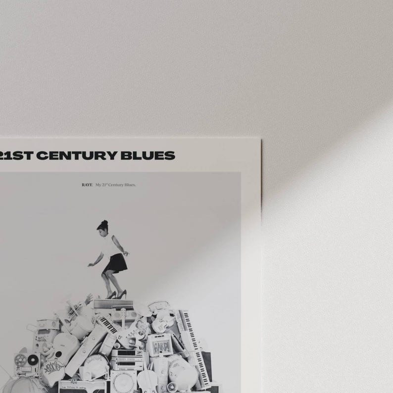 May include: A black and white poster with the text "21ST CENTURY BLUES" at the top. The image features a person standing on a pile of musical instruments and equipment. The person is wearing a white top and a black skirt.