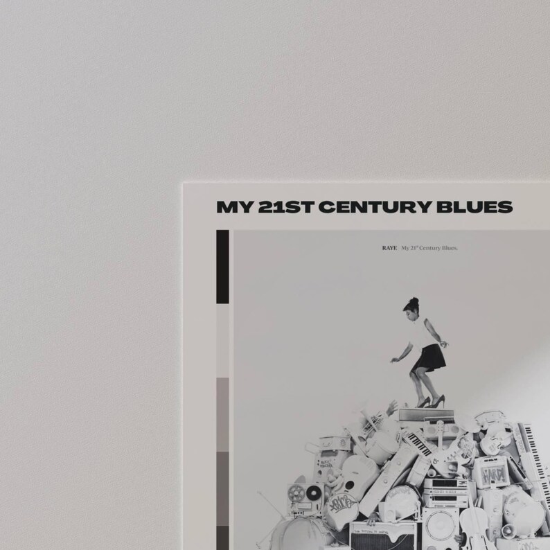 May include: A poster with the text "MY 21ST CENTURY BLUES" at the top. The poster features a black and white image of a person standing on a pile of electronic devices. The poster has a minimalist design with a color block on the left side.