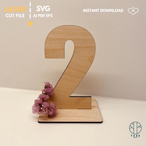 May include: A wooden number two, laser cut, with a small rectangular base. The number is decorated with small pink flowers. The image includes the text "LASER CUT FILE SVG AI PDF EPS" and "INSTANT DOWNLOAD".