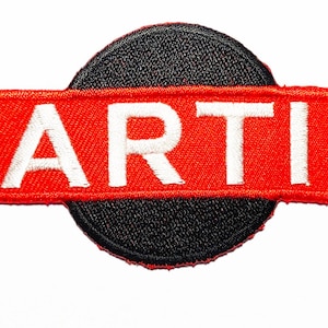 Op de afbeelding: Een geborduurde patch met het woord "MARTINI" in witte letters op een rode achtergrond. Een zwarte cirkel bevindt zich achter het rode rechthoek.