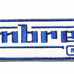 Può includere: Toppa ricamata blu con la parola "Lambretta" e il testo "Innocenti" in un carattere più piccolo sotto.