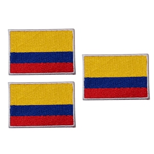 Puede incluir: Tres parches rectangulares bordados con la bandera de Colombia. Cada parche tiene una sección superior amarilla, una sección media azul y una sección inferior roja, con un borde blanco.