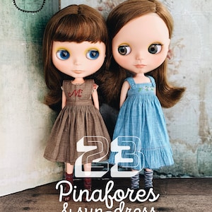 May include: Two dolls wearing pinafores and a sun dress. The dolls have brown hair, blue eyes, and are wearing colourful socks. The dolls are standing on a wooden surface. The text "23 Pinafores & sun-dress" is written in white letters on a black background.