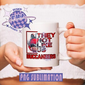 Pu&ograve; includere: Tazza in ceramica bianca con un design rosso e nero. Il design presenta un casco da football e il testo "They Not Like Us Buccaneers".